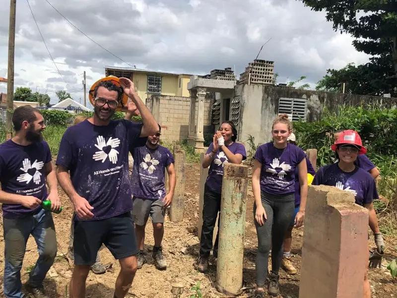 Dirt covered students take a break from repair work in Puerto Rico.