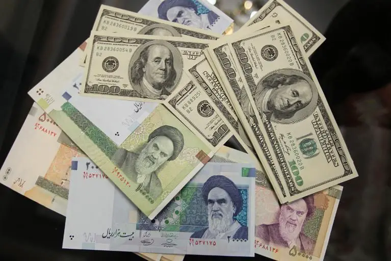 United States 100-dollar bills and various Iranian Rial banknotes in Tehran on January 18, 2012.