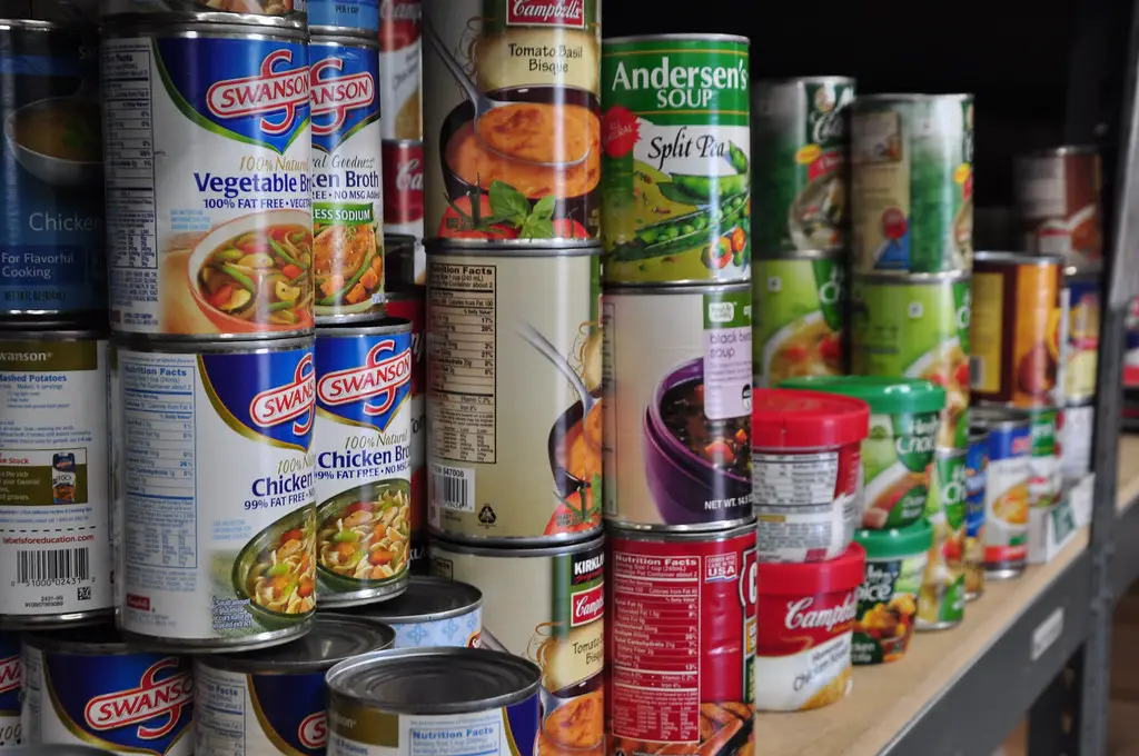 A collection of canned food items in a pantry.