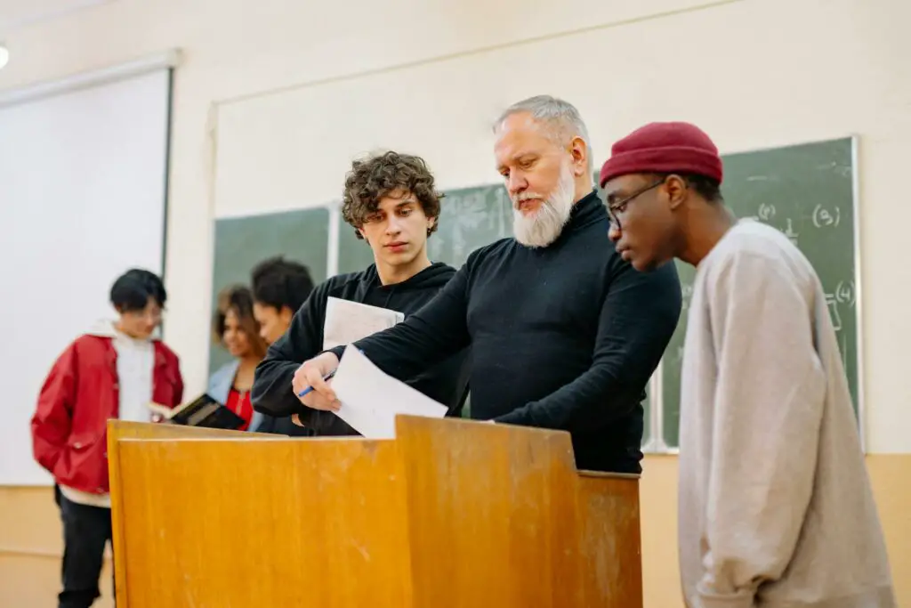 A teacher surrounded by students engaged in a lively discussion to prepare for college midterms