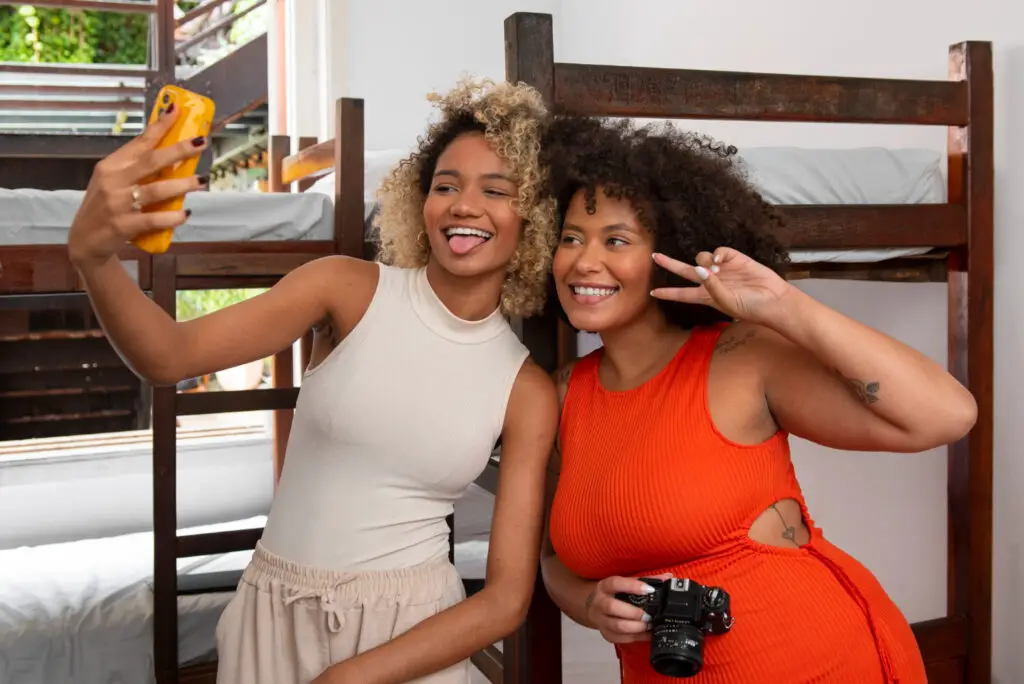 Two female college roommates taking a selfie using a cellphone