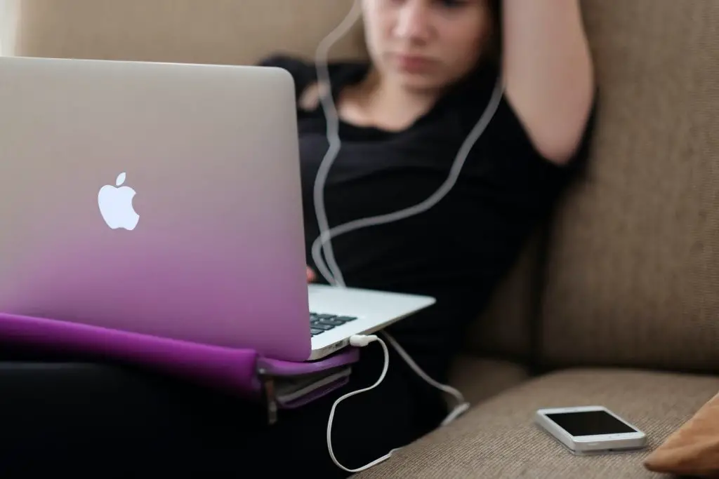 Photo of a woman sitting a couch with her laptop