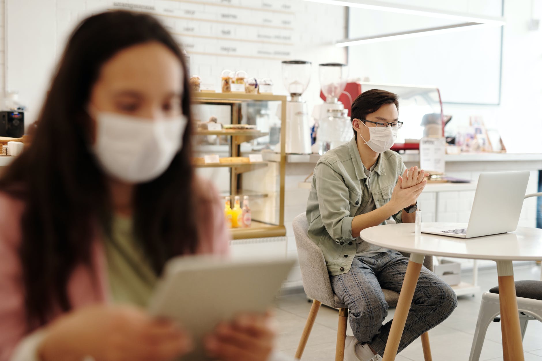 Photos of students sitting in a coffeeshop while wearing facemasks.