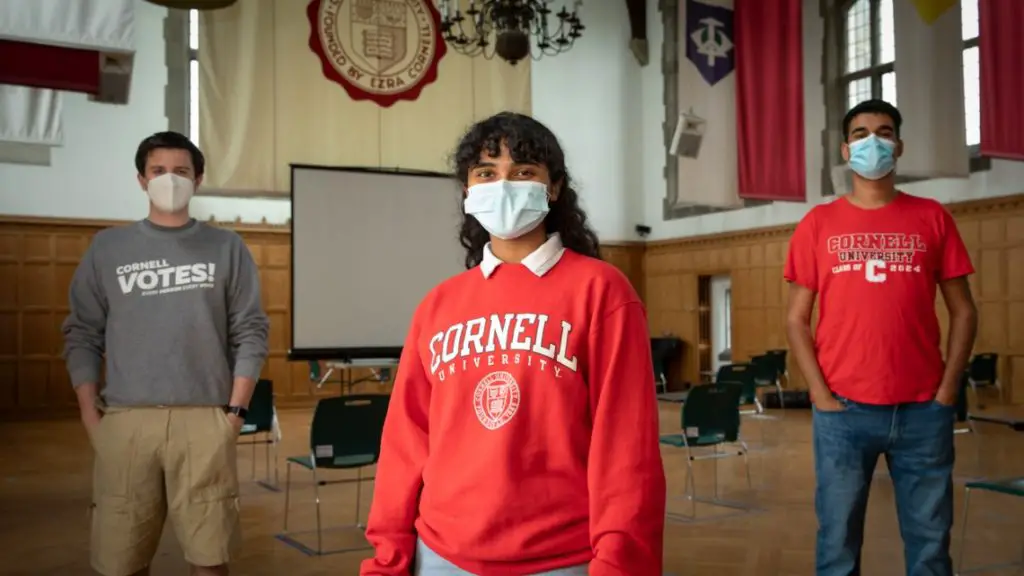 Three socially-distanced and masked students from Cornell Votes