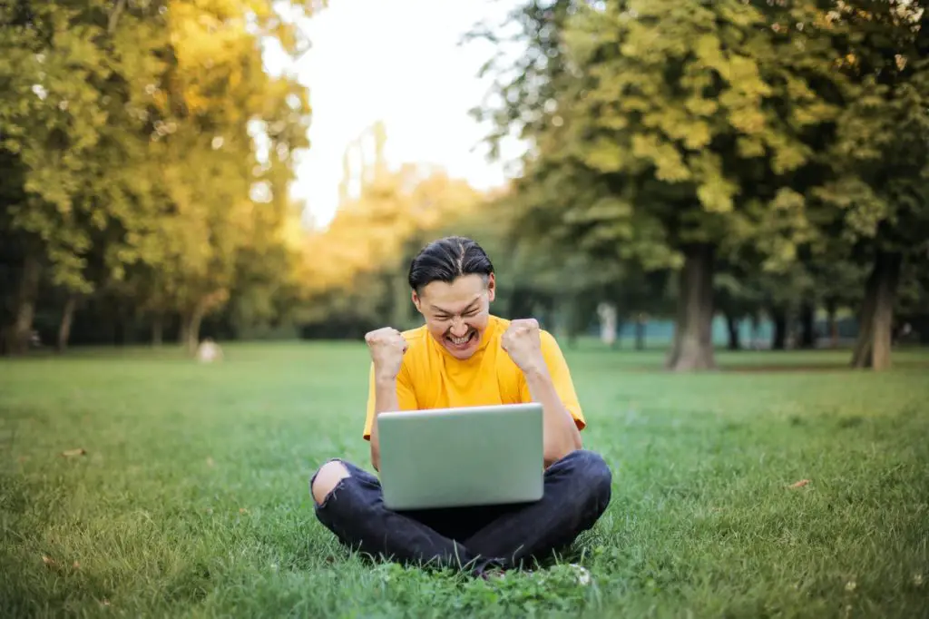 photo-of-community-college-student-sitting-on-lawn-happy-with-free-college