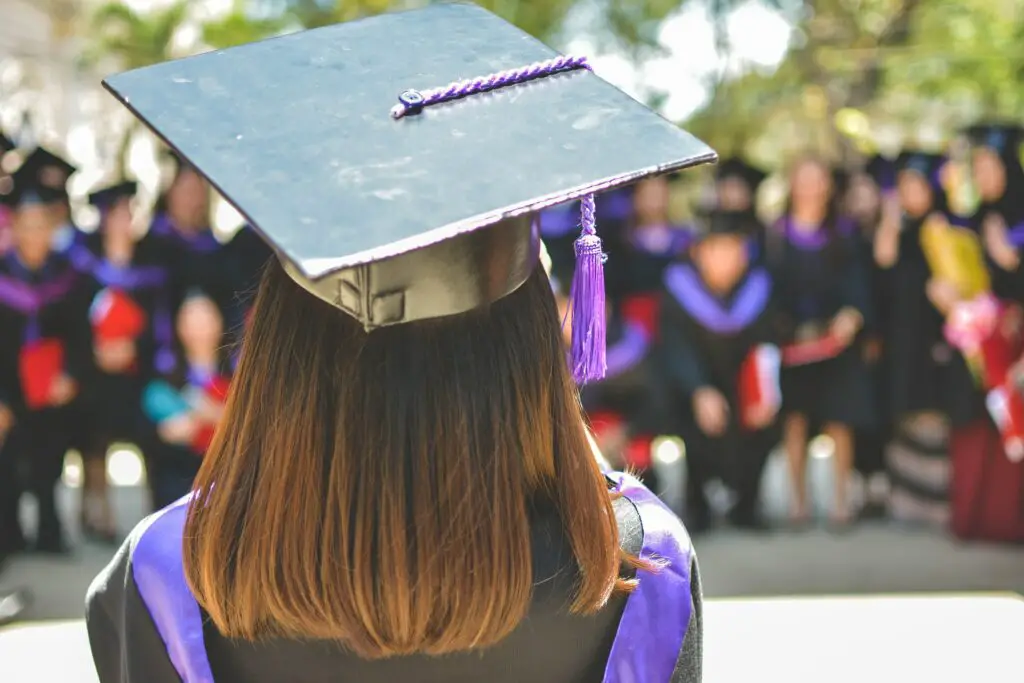 Back angle shot of a female graduate wearing a graduation cap and toga