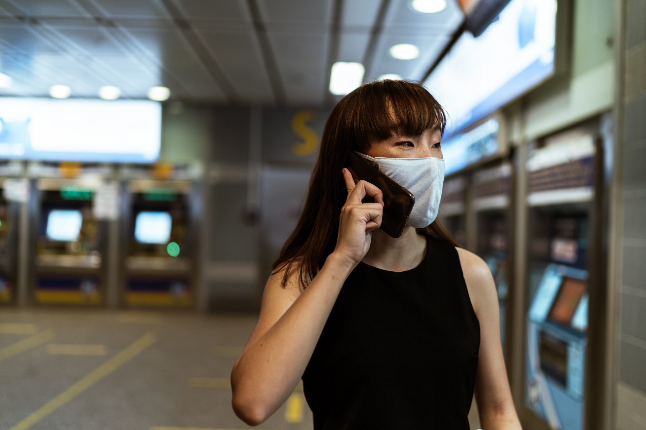 female student wearing mask talking on cellphone