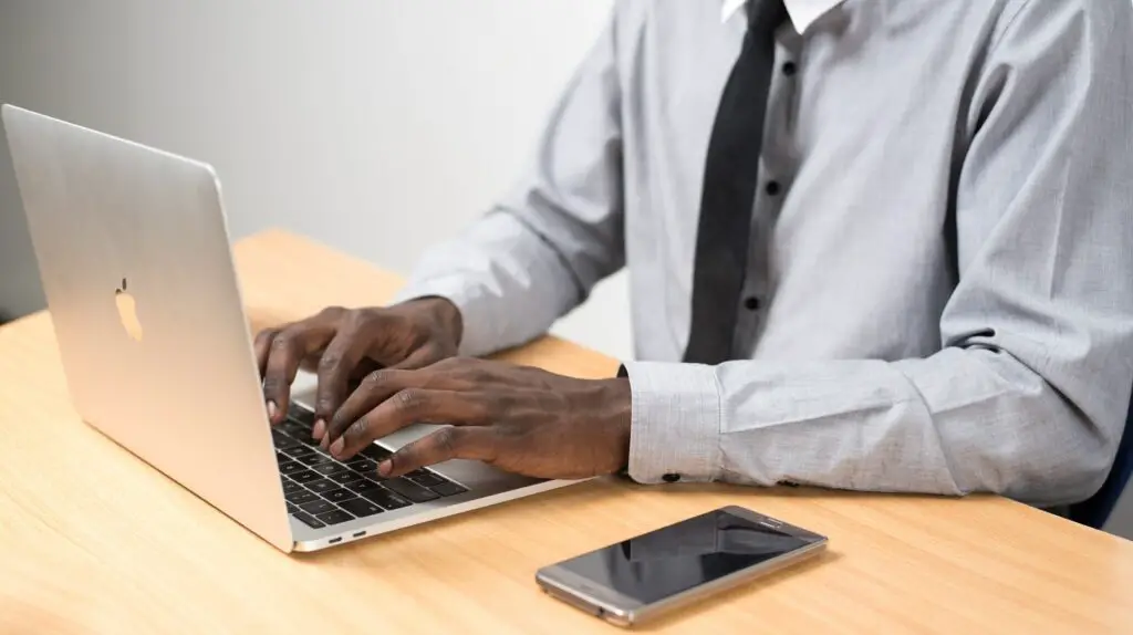 Photo of a man sitting behind a laptop