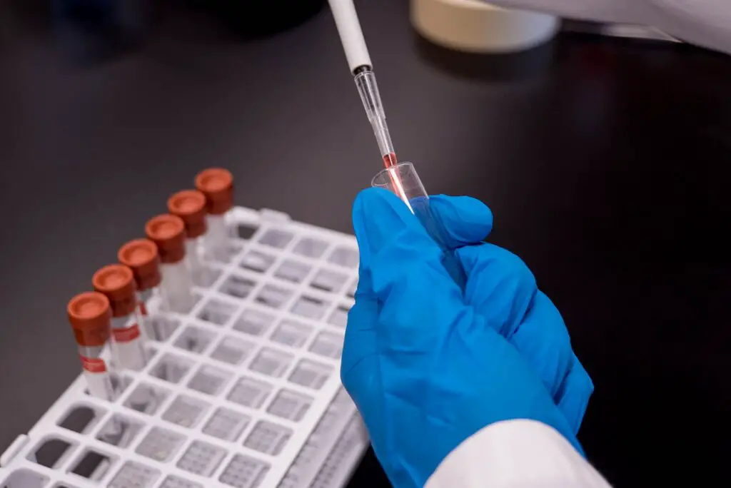 lab assistant putting solution inside a test tube