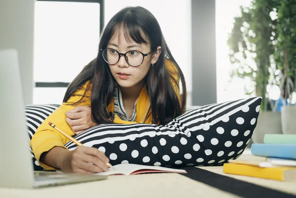 Female college student opting for online learning at home in one of the cheapest colleges using laptop
