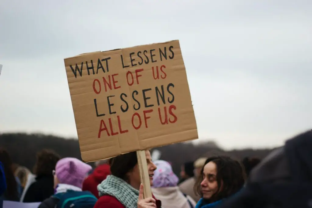 women holding protest sign about equality