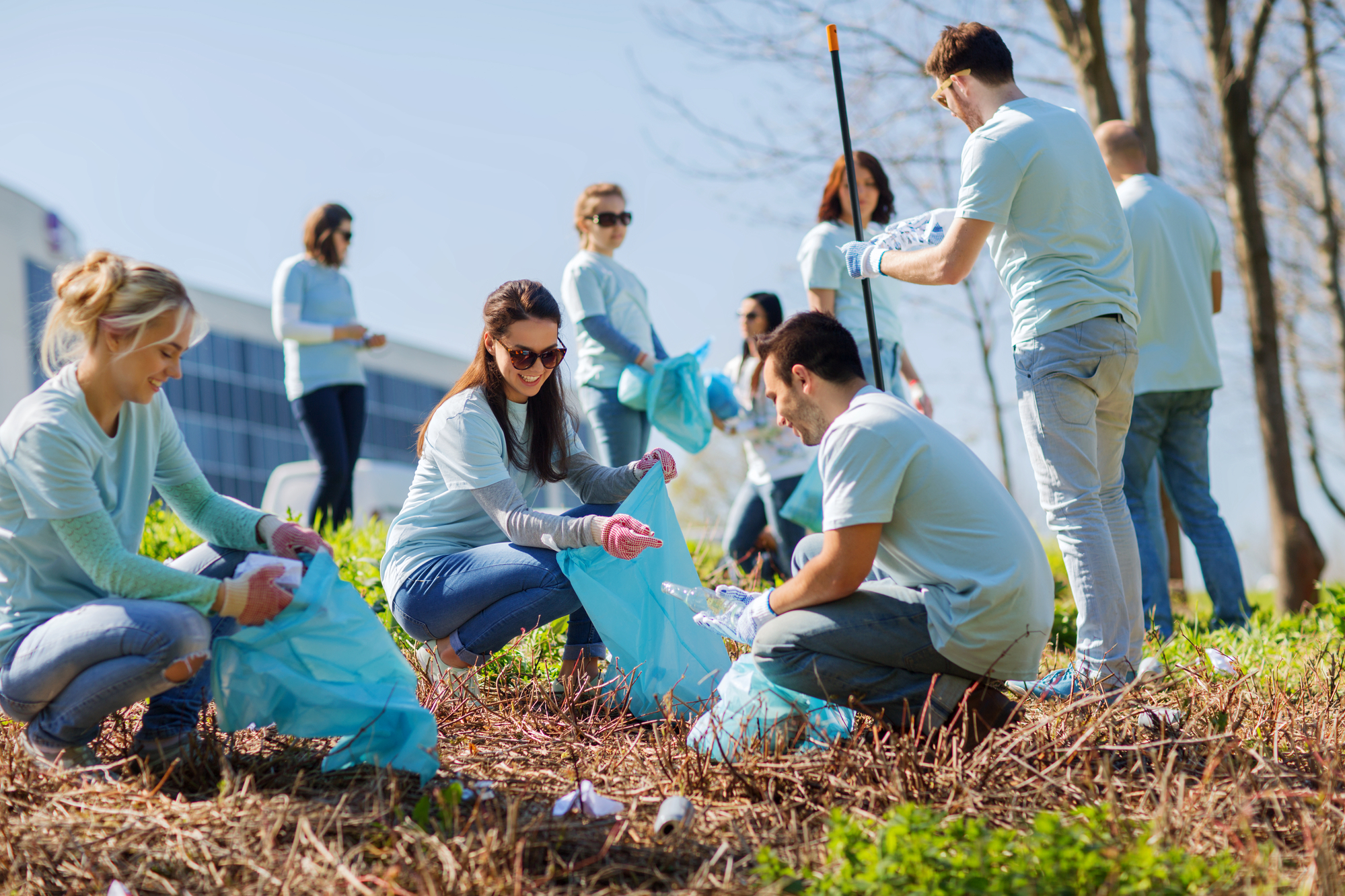 a group of female and male college students doing an environmental cleanup as part of their internship