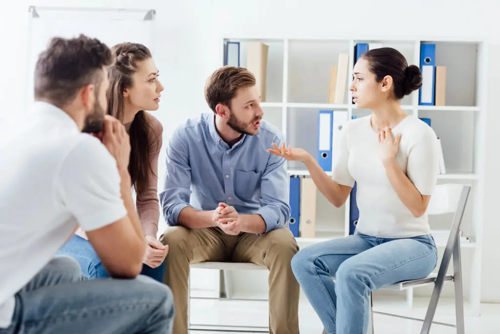 A diverse group of students engaged in a lively discussion with the career counselor while sitting in a circle.