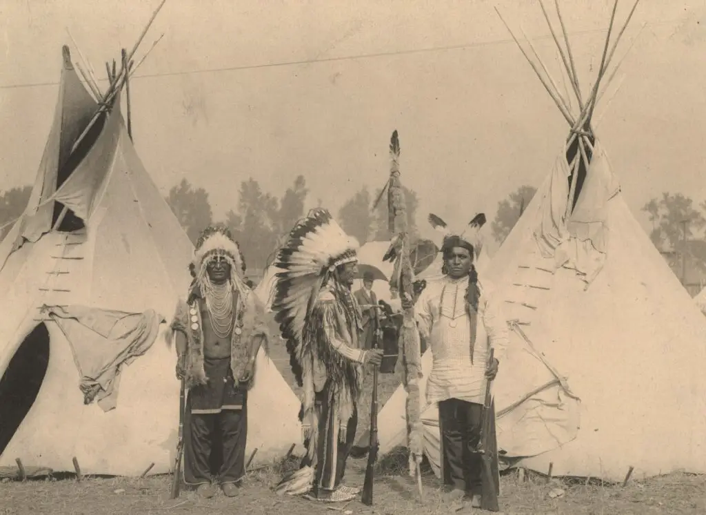 Three members of the Sioux tribe pose in Indian Village, 1898.