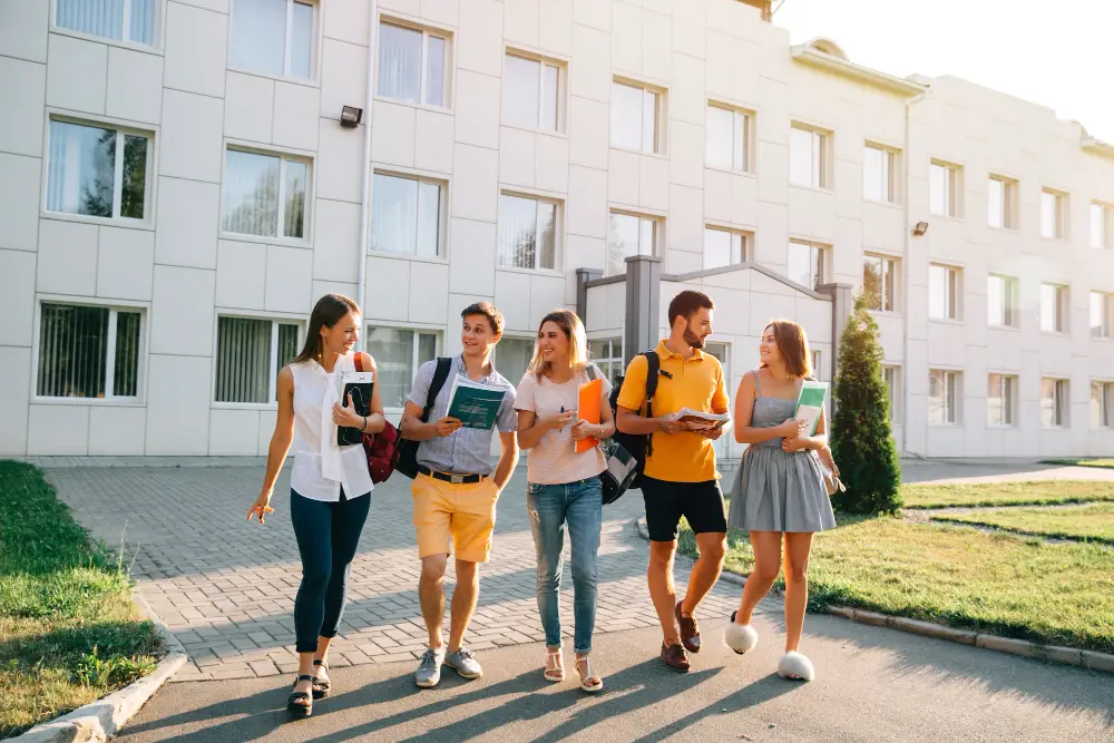 Five college students walking away from the campus building