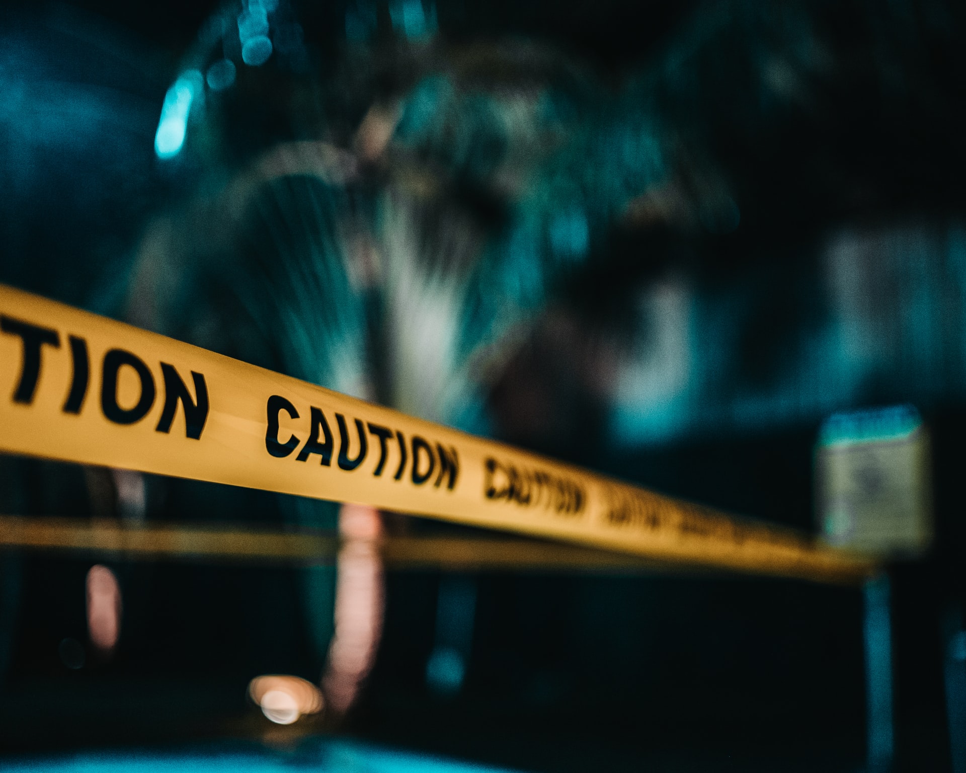 Photo of a police tape reading "caution" at a crime scene