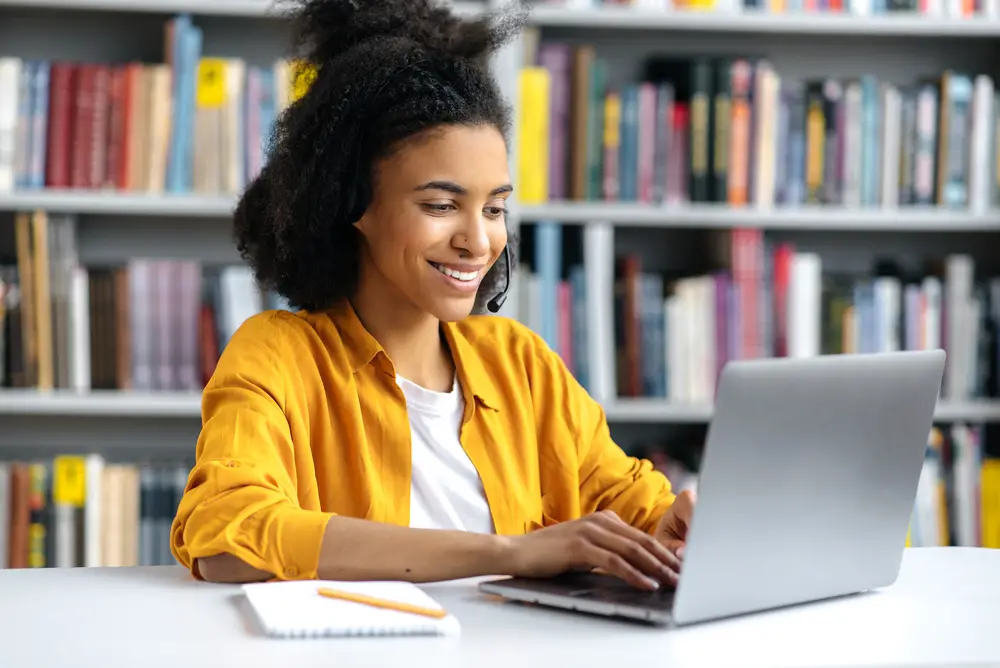 A smiling African-American female college student researches top college majors that pay well