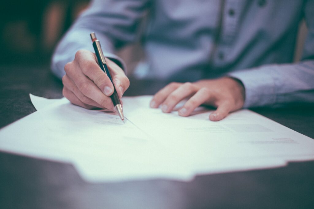 Man writing or signing a document.