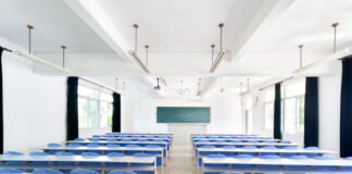Bright empty classroom with desks and chairs