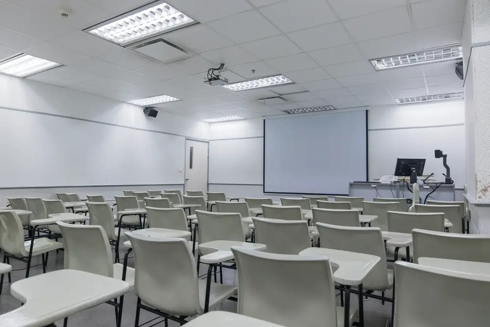 Empty school classroom interior with desk and projector