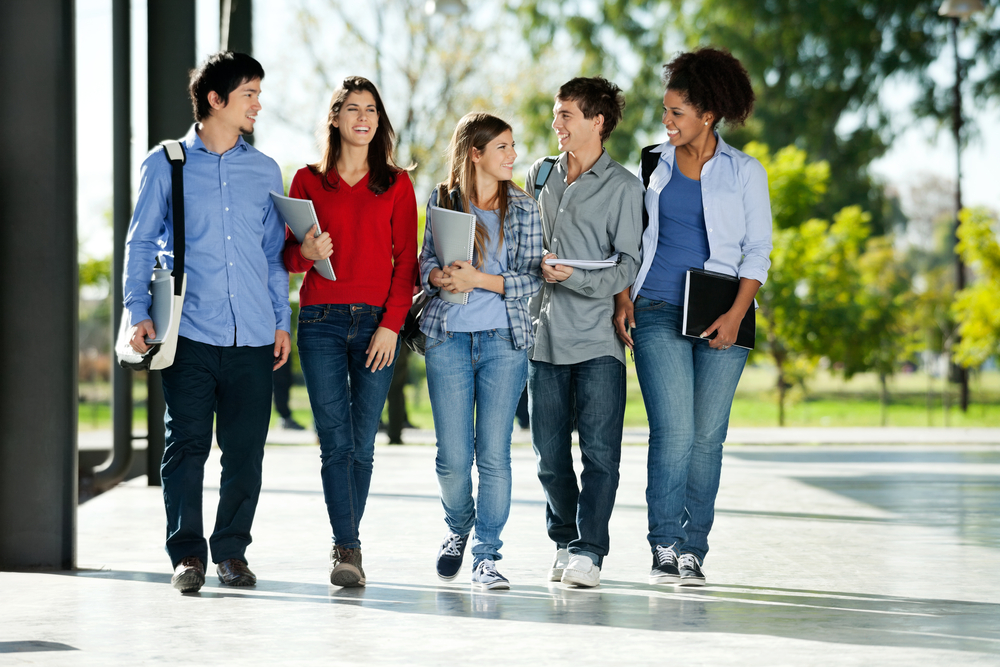 Happy college students walking together on campus