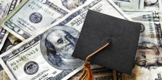 Miniature graduation cap on hundred dollar bills