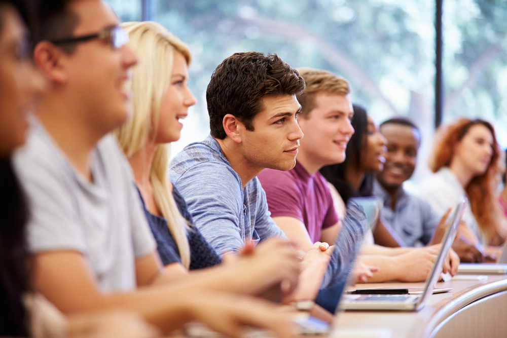 Class of university students using laptops during a lecture