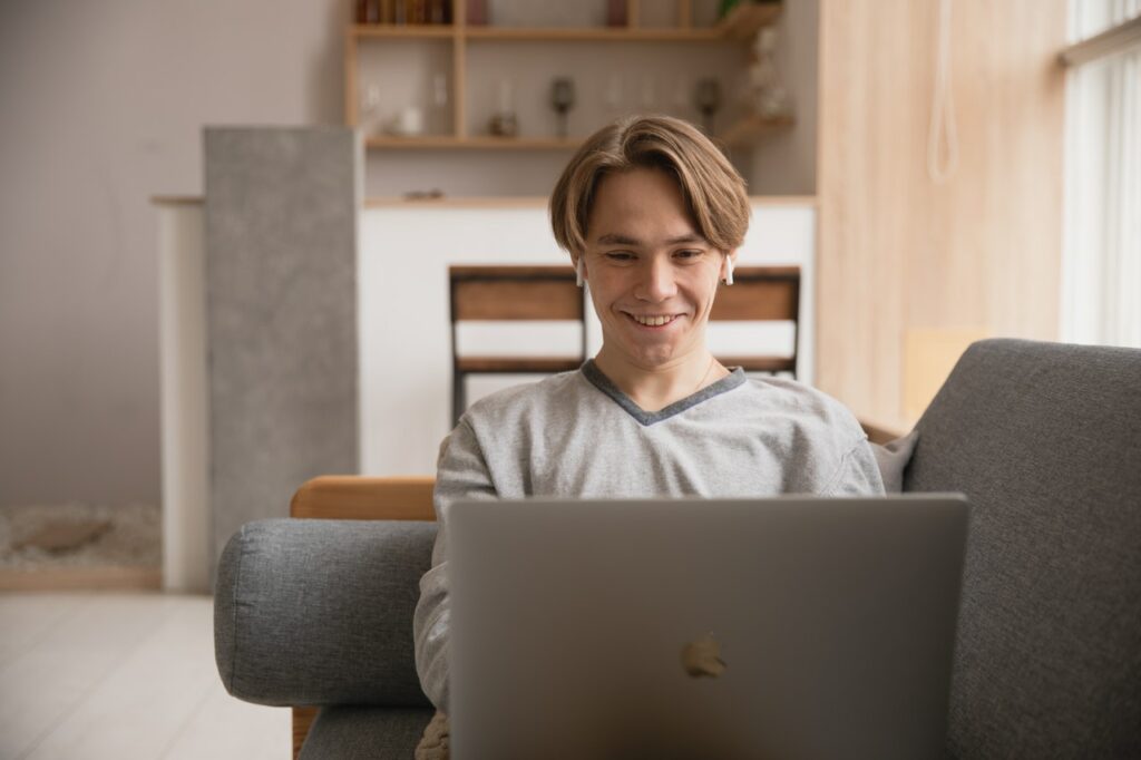 photo-of-male-student-applying-for-college-scholarship-and-grants-on-laptop