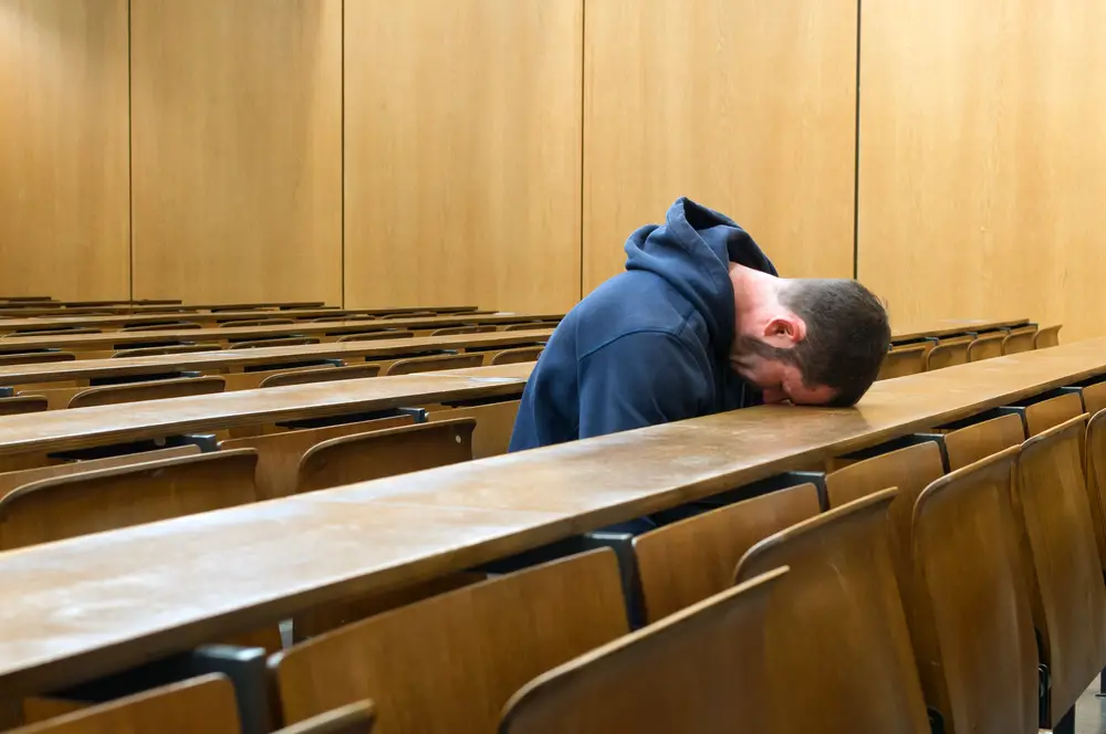 Student napping in an empty classroom