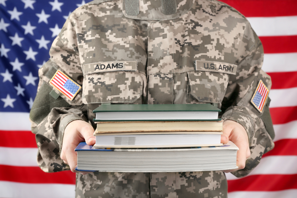 Female soldier holding books, with USA flag on background