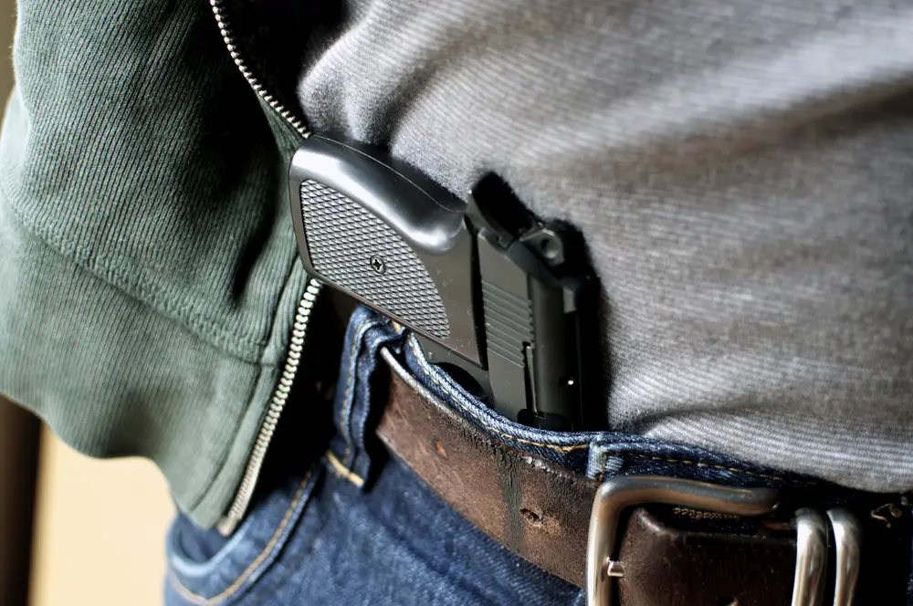 Pistol tucked in a belt being concealed