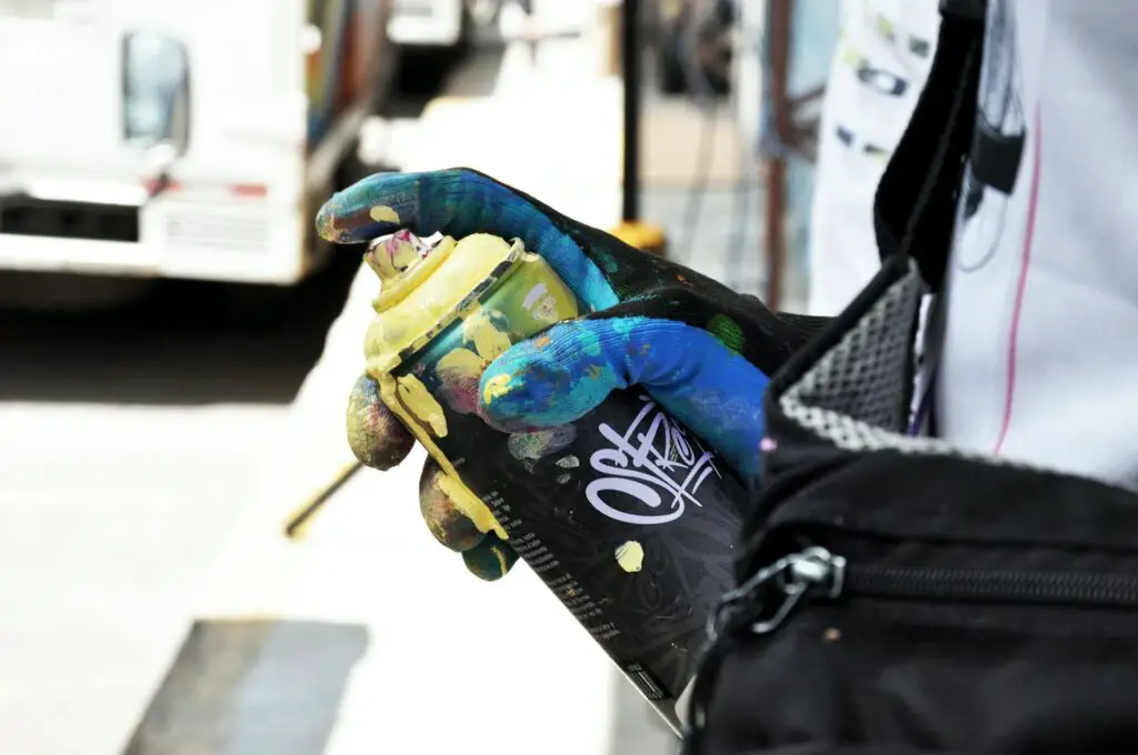 Close up of someone holding a can of yellow spray paint