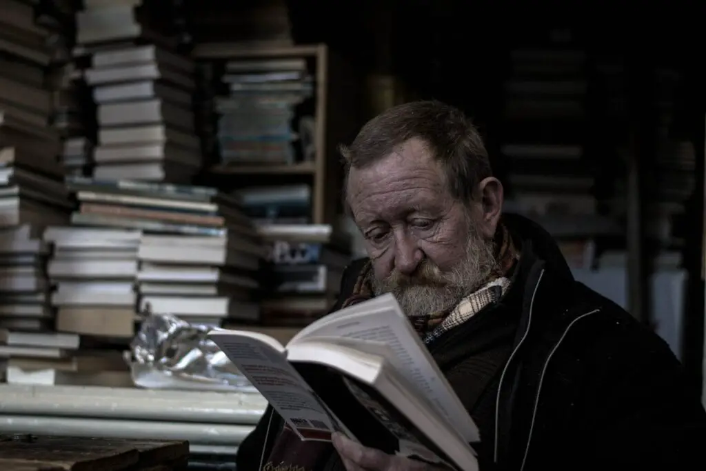 An elderly man reading a book.