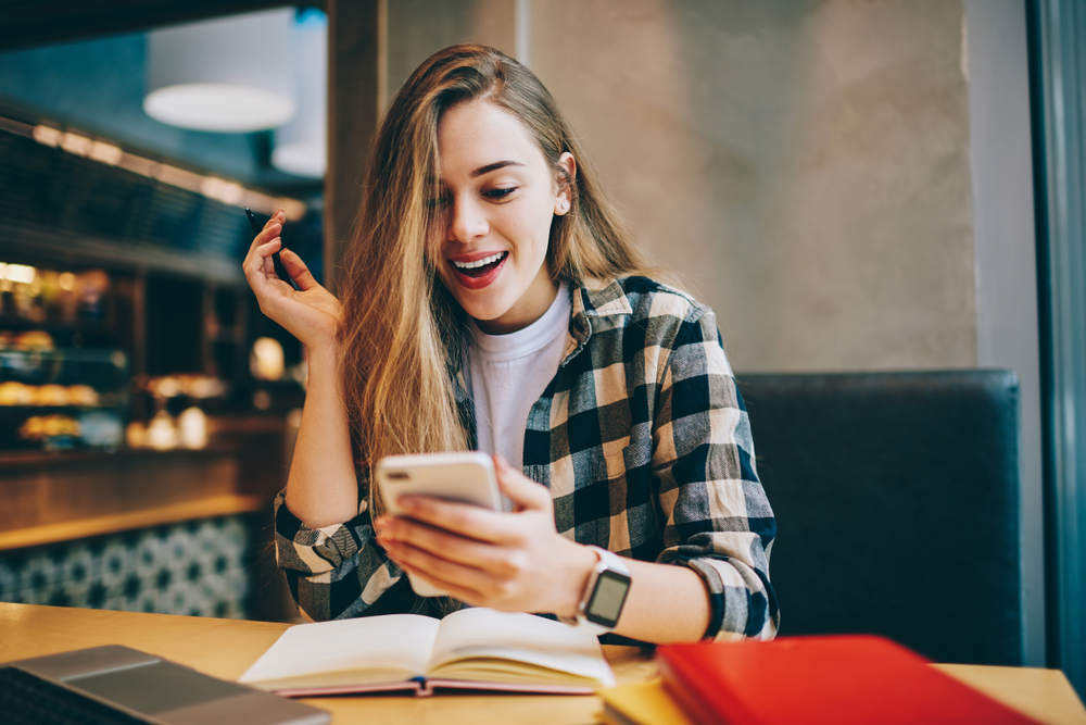 A girl is amazed while reading on her mobile phone