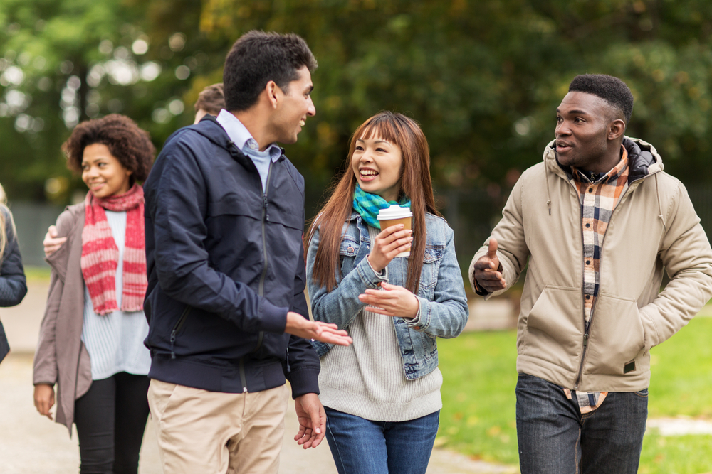 Students talk to each other while walking on campus