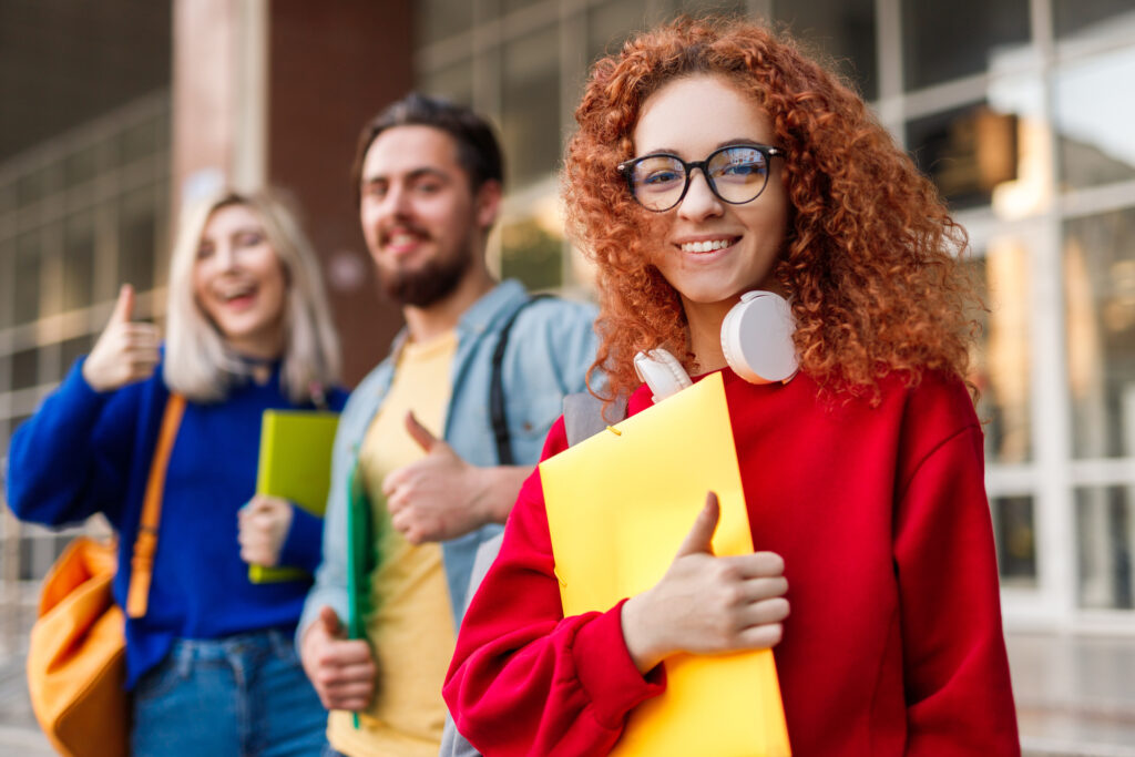 two female and one male high school students smiling for the camera preparing for college application