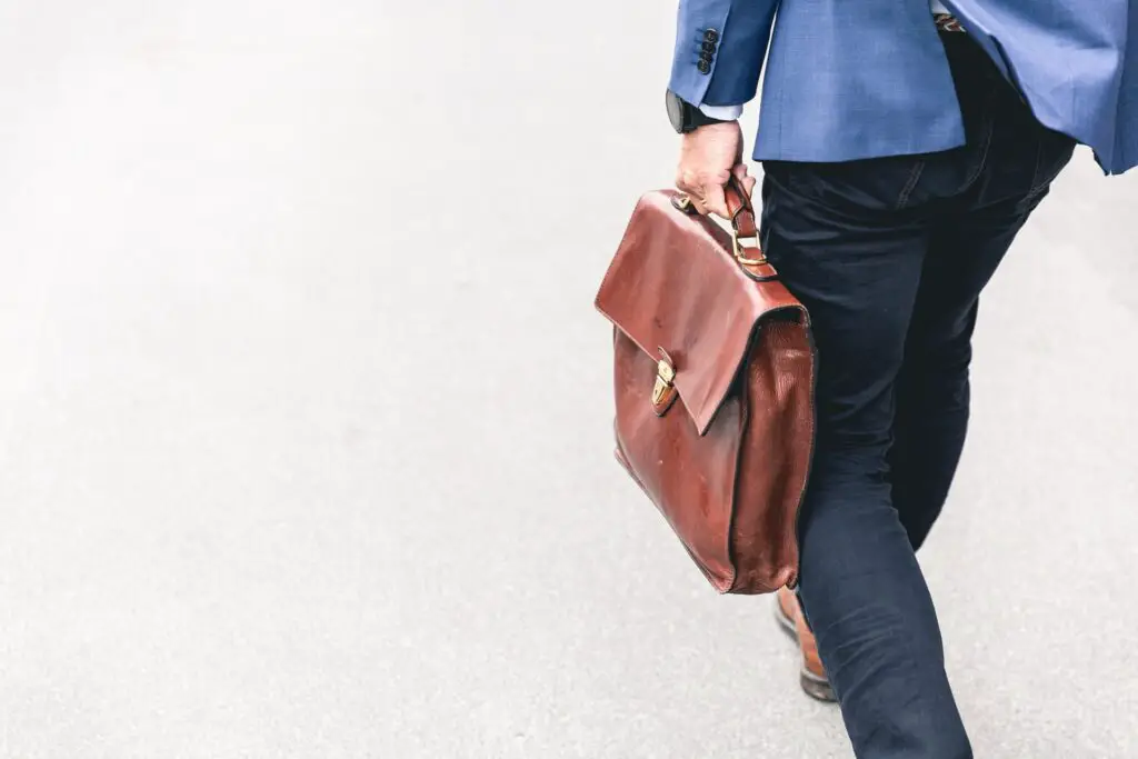 Man with a leather suitcase walking away.