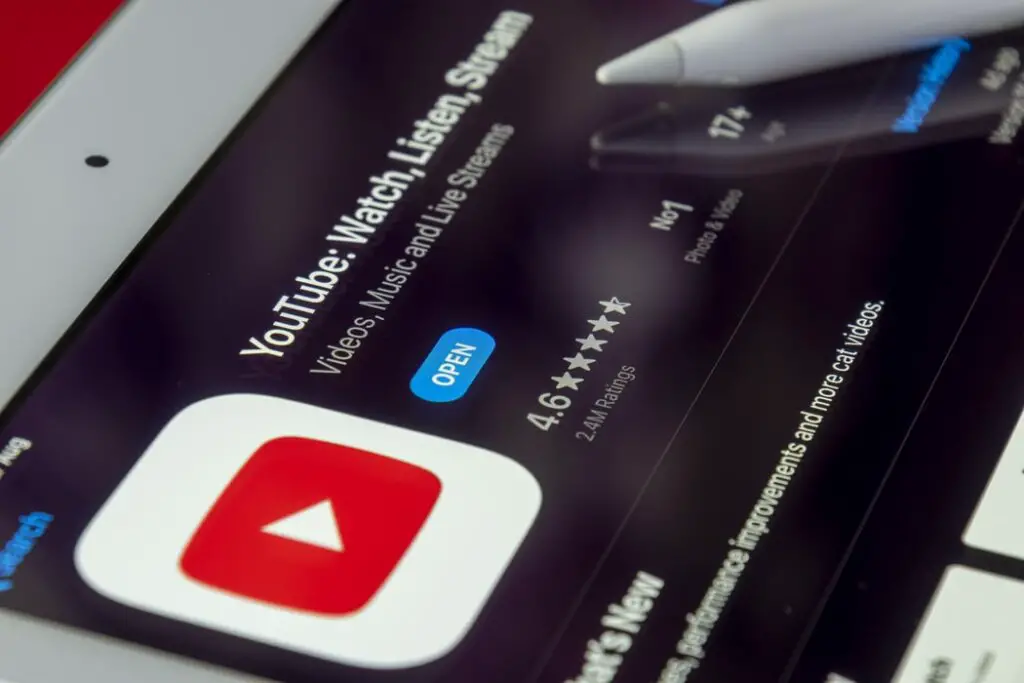 A tablet displaying the YouTube logo with a stylus pen by the side