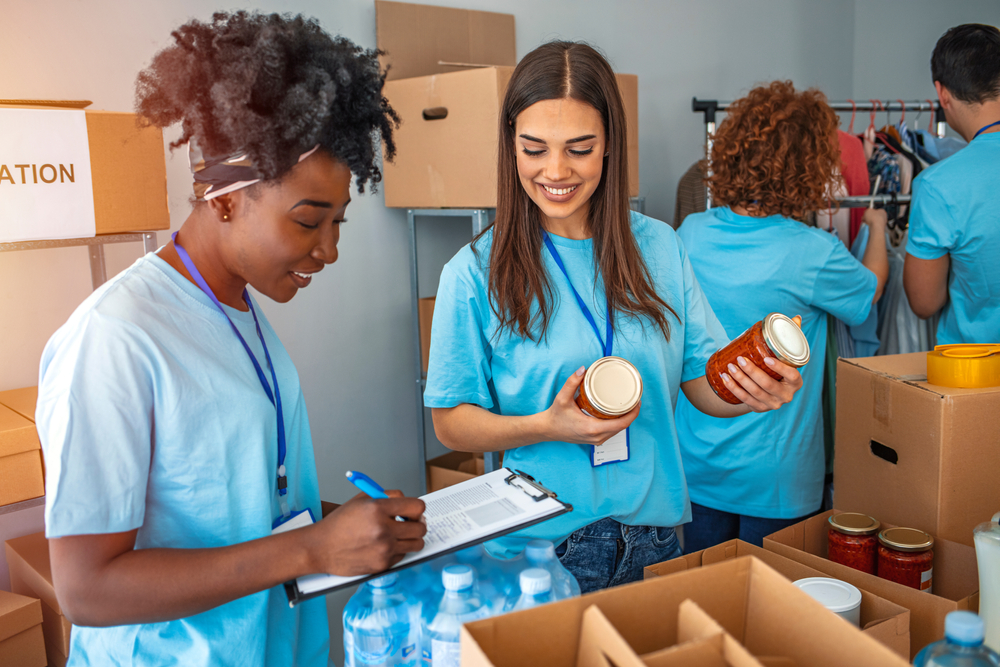 female high school students doing an inventory of donated goods at the volunteer site