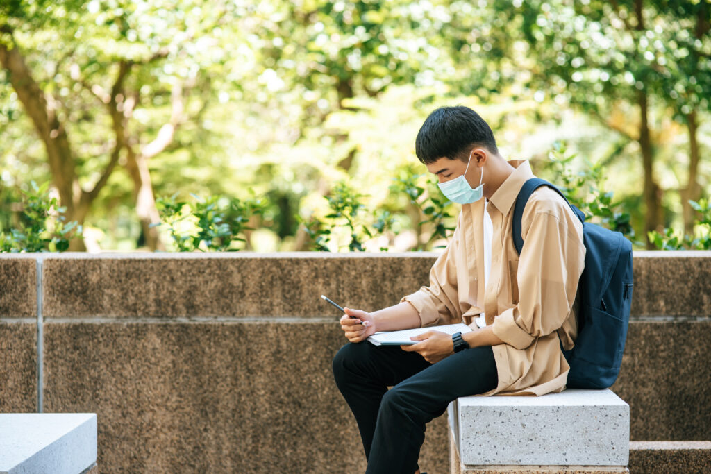 young asian college student sitting down and looking at his FAFSA 2023-24 application