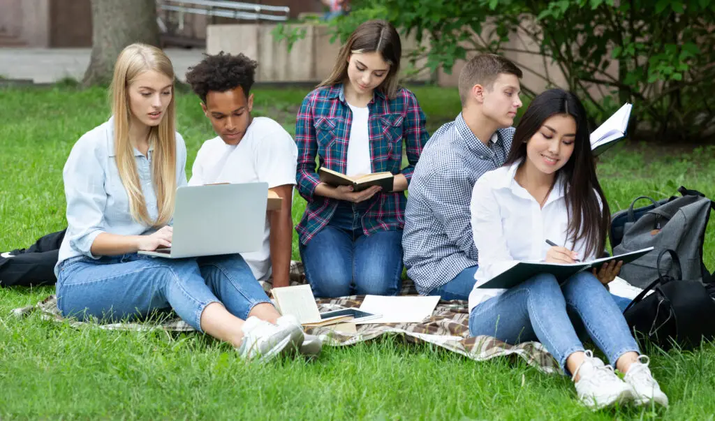 a group of male and female college students sitting outdoors