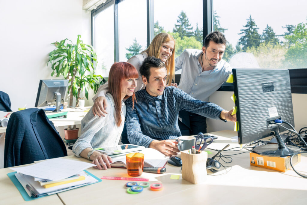 photo-of-four-young-interns-pointing-at-screen