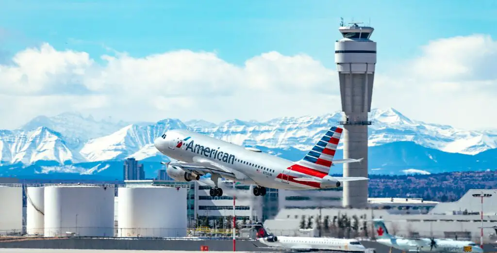 American airplane taking off with a control tower at the background