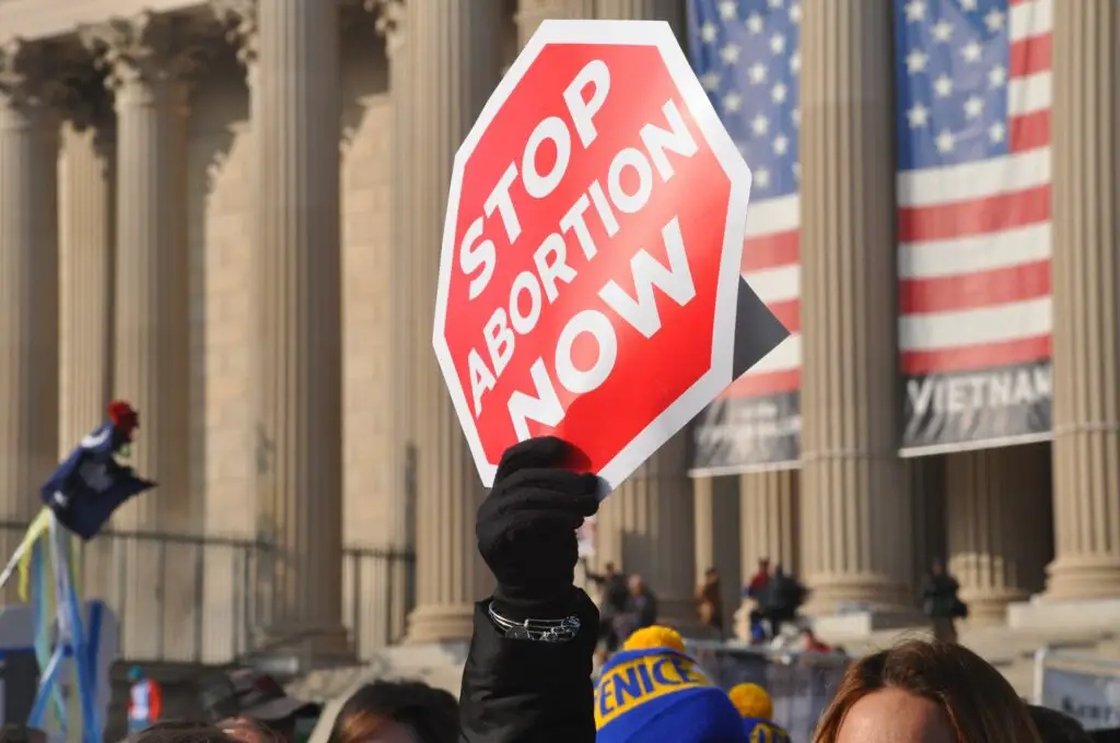 man holding a pro-life sign at the March for Life protest