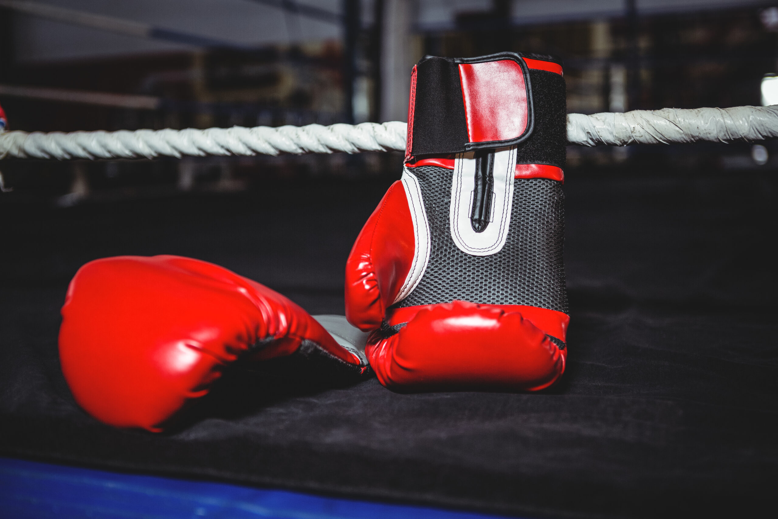 Pair of red boxing gloves in boxing ring
