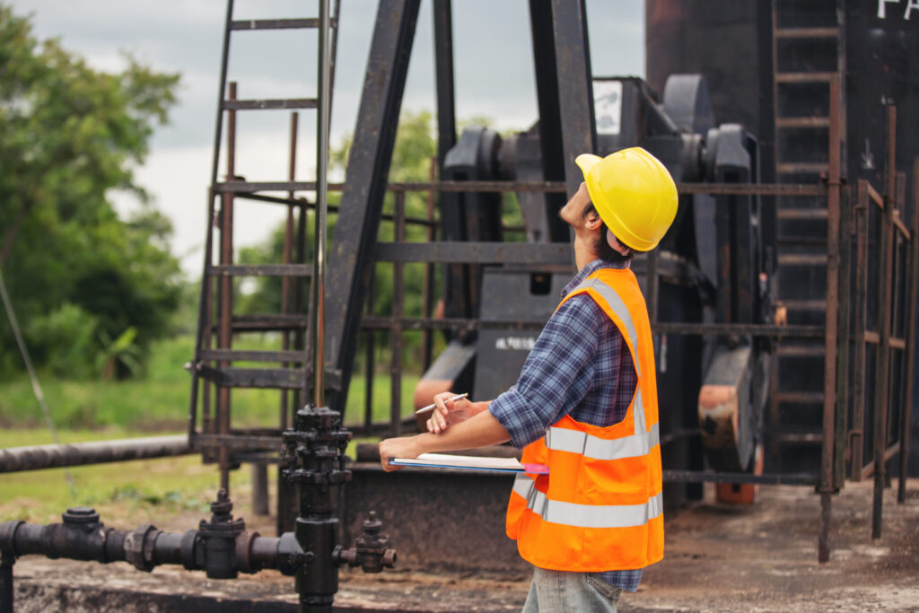 petroleum-technician-standing-by-oil-well-with-trade-school-degree