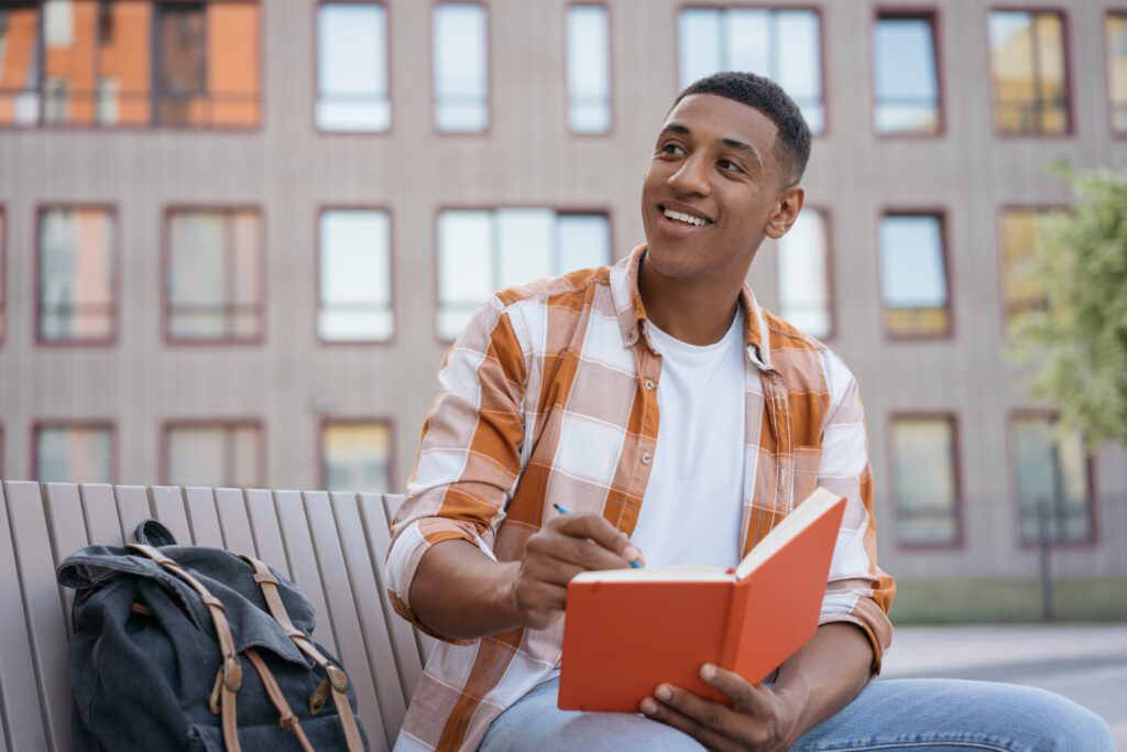 photo-of-african-american-student-at-writers-college-writing-in-book