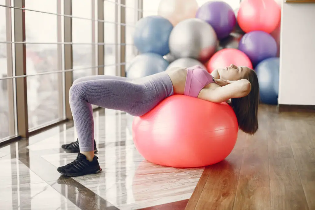 young-female-student-working-out-on-exercise-ball