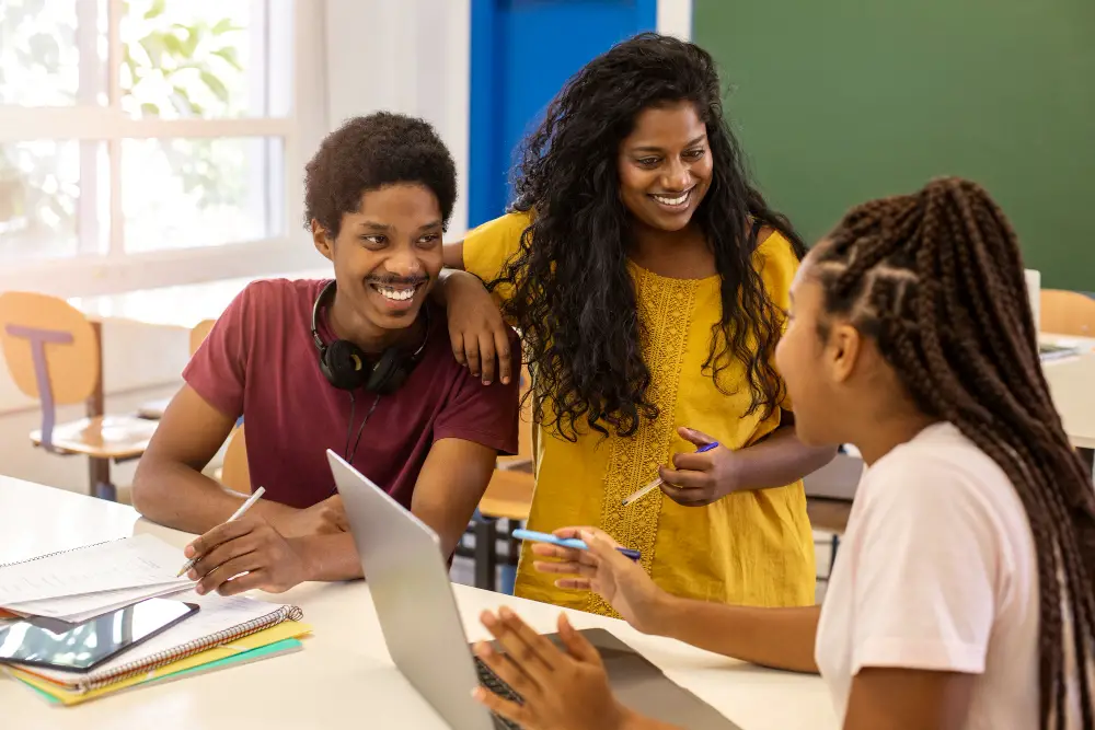 Three students of different ethnicities from a tuition free college discussing their group project 