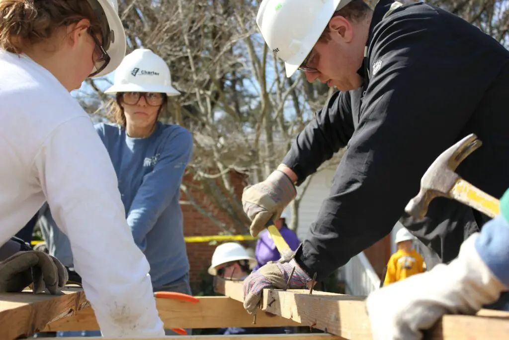 a group of young and old people working on a construction project